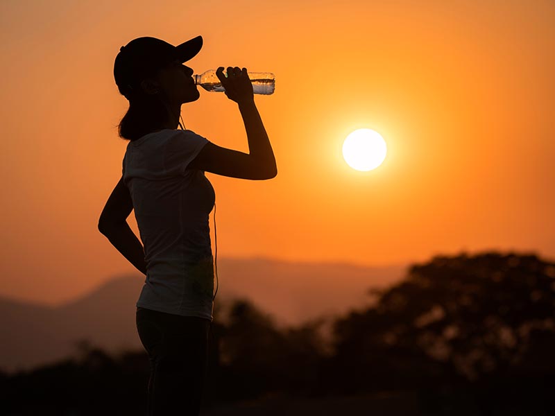 Dehydrated runner fitness woman drinking water bottle sports drink